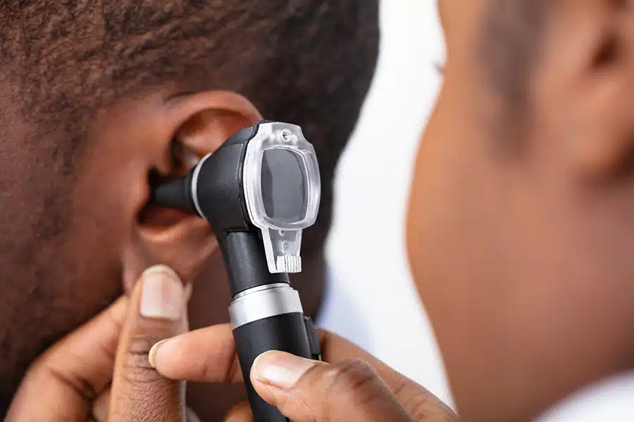 doctor conducting a hearing exam with an otoscope