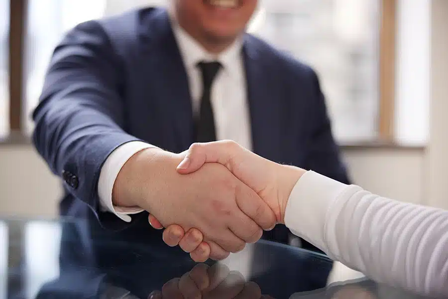 Attorney shaking hands with a client after a successful l&i settlement