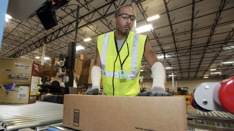 warehouse worker in safety vest handling boxes