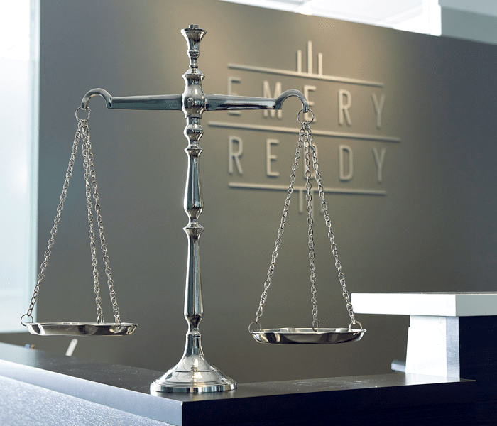 scales of justice in front of emery reddy seattle l&i attorneys logo