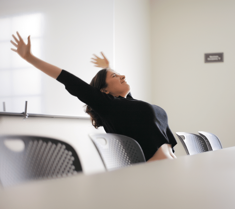 woman stretching at a conference table