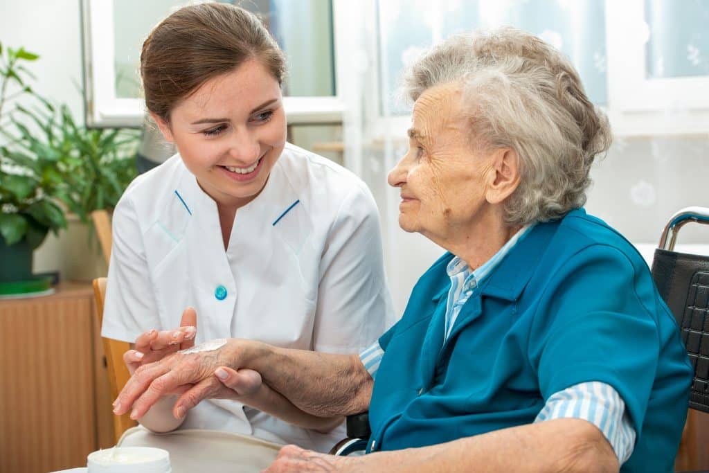 home heathcare worker helping a senior woman with her skin care