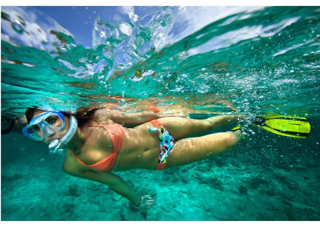 woman in a bikini swimming under water with a snorkel