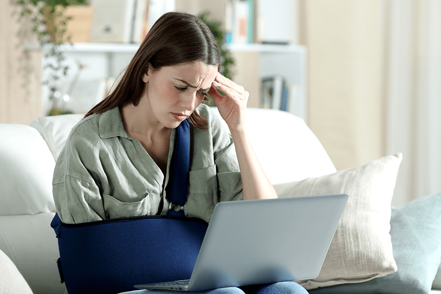 Worried handicapped woman reading her l&i claim on laptop