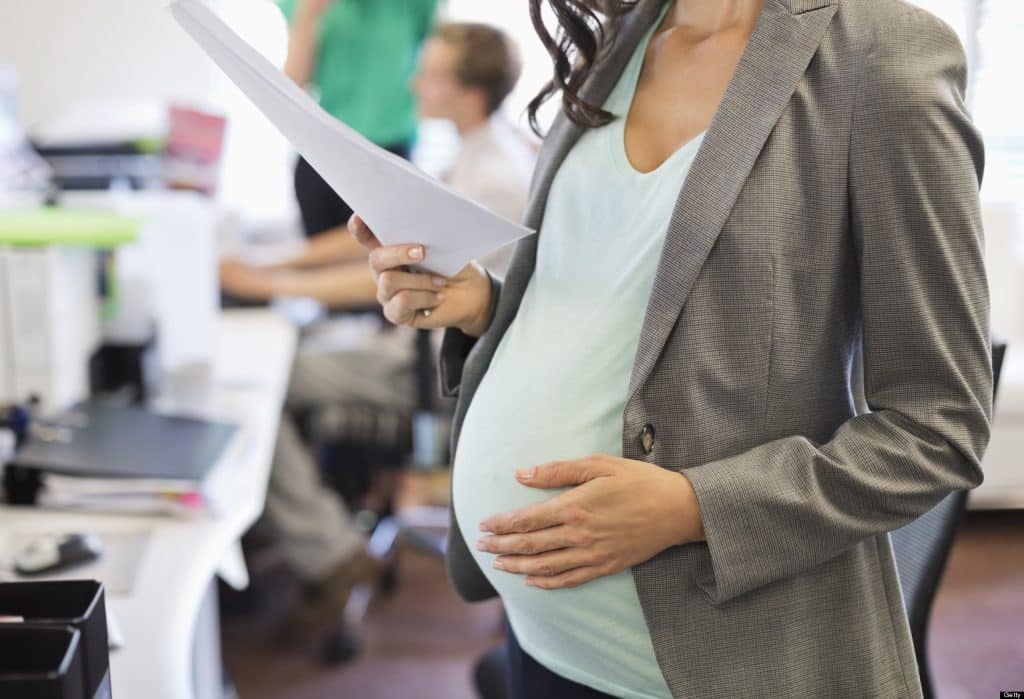 close up of a pregnant woman in an office setting