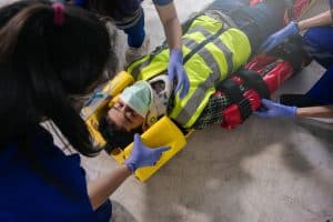 Employee accident in construction site work. Team EMS paramedic first aid for head injuries. Paramedic team first aid builder accident in site work. Emergency service. First aid procedure.