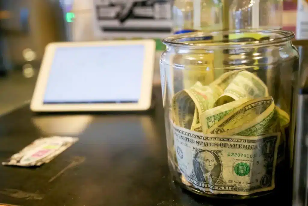 A tip jar at City Grind coffee stand in Seattle. The Seattle City Council will soon begin discussing legislation to slow the 10-year rollout of the city’s minimum wage for small businesses. (Greg Gilbert / The Seattle Times, 2023)