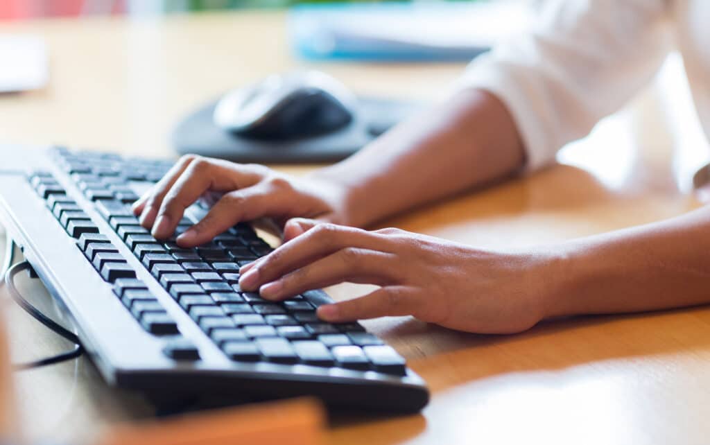 business, education, programming, people and technology concept - close up of african american female hands typing on keyboard